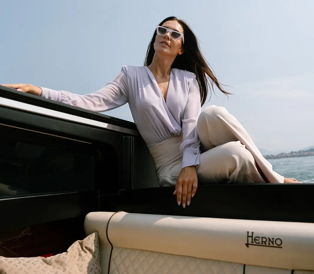 Donna seduta su barca Aurum, si intravedono i sedili marchiati Herno